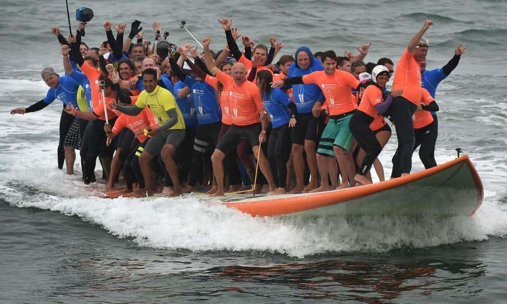 World Record Set When 66 People Ride One Surfboard At The Same Time